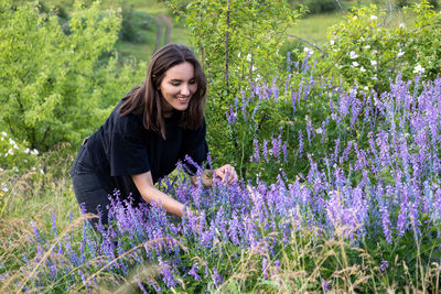 Portrait of young woman standing amidst plants