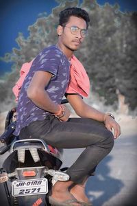 Portrait of young man sitting on outdoors