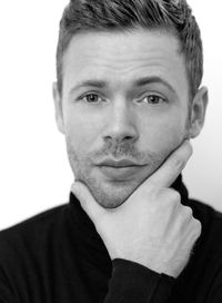 Close-up portrait of mid adult man with hand on chin against white background