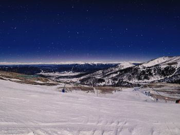 Scenic view of snowcapped mountains against sky at night