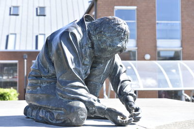 Statue against building in city