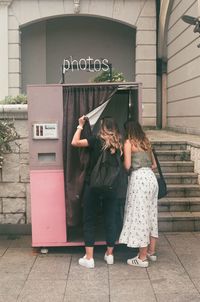 Rear view of women standing with text