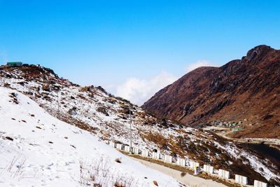 Scenic view of snowcapped mountains against blue sky