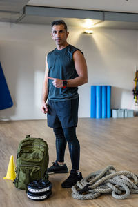 Full length portrait of man standing against wall