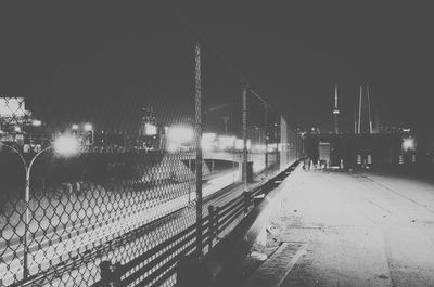 Railroad station platform against sky at night