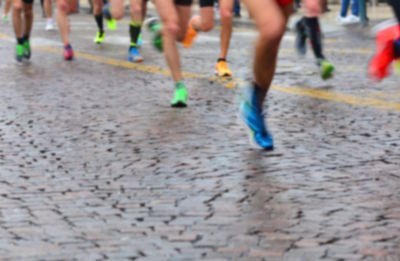 Low section of people running on street