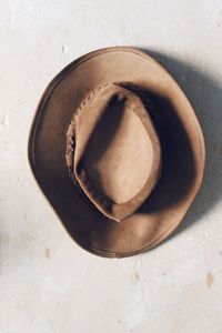 View of brown suede hat from above on rustic white background 
