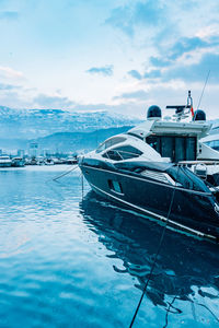 Boats moored at harbor against sky