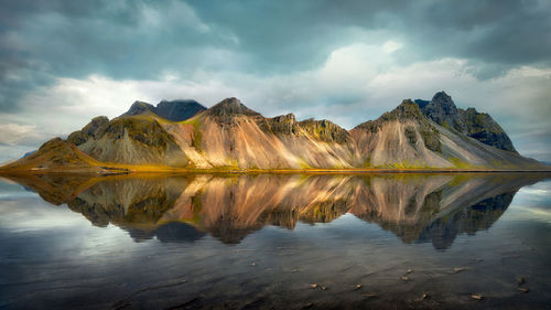 Scenic view of lake by mountains against sky