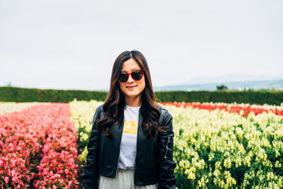 Portrait of smiling young woman standing on field