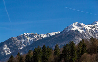 Scenic view of snowcapped mountains against blue sky