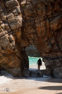 Person walking in cave at beach