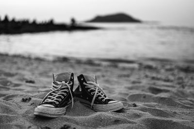 Close-up of shoes on beach