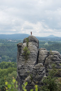 Man standing on cliff against sky