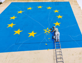 High angle view of men standing against blue wall