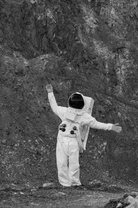 Rear view of an astronaut in space suit standing on field