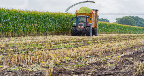 Agricultural machinery on field against sky