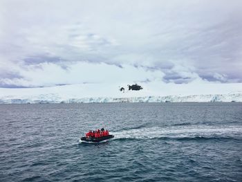 High angle view of people rafting in sea against sky