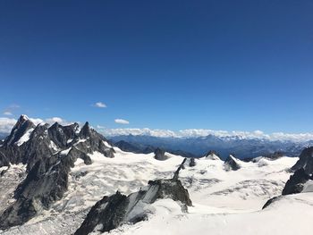 Scenic view of snowcapped mountains against clear blue sky