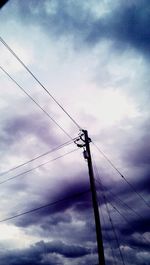 Low angle view of power lines against cloudy sky