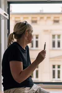 Side view of young man using mobile phone