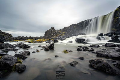 Scenic view of waterfall against sky