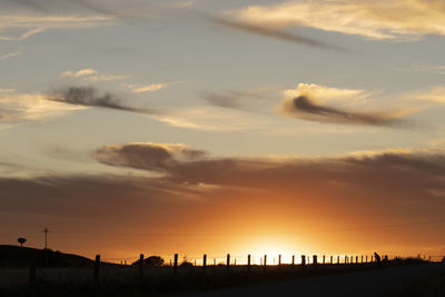 Low angle view of silhouette fence against sky during sunset