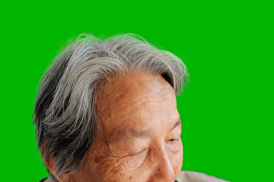 Close-up portrait of man against gray background