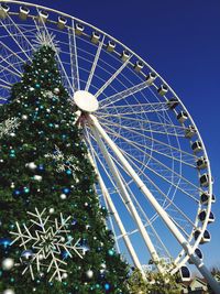 Low angle view of illuminated ferris wheel against blue sky