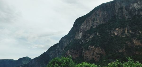 Low angle view of rocky mountains against sky