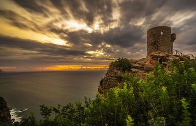 Old ruin building against cloudy sky during sunset