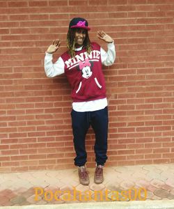 Full length portrait of young woman standing against brick wall