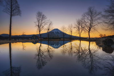 Scenic view of lake against sky at sunset