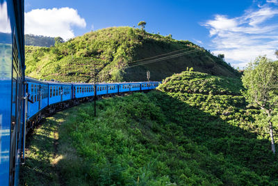 View of train passing amidst trees against sky