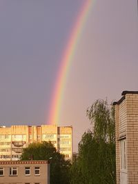 Low angle view of rainbow over buildings in city