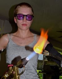 Young woman burning metal with welding torch