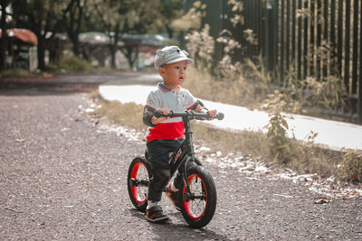 Portrait of cute toddler boy riding a push bike