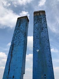 Low angle view of wooden post against sky