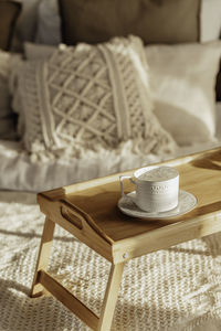 Wooden table with cup, empty bed, brick wall. bedroom modern and cozy interior. soft pillow