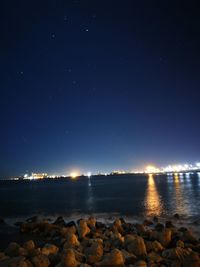 Scenic view of lake against clear sky at night