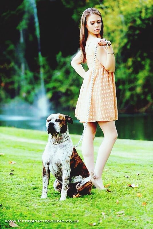 full length, animal themes, person, one animal, lifestyles, casual clothing, grass, looking at camera, front view, young adult, portrait, young women, leisure activity, park - man made space, standing, field, focus on foreground, dog