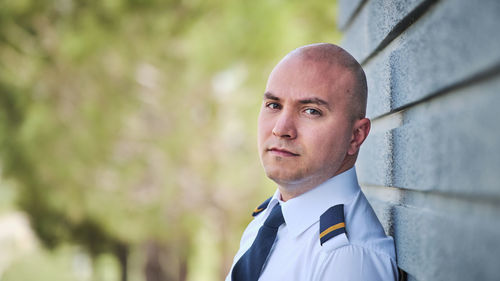 Portrait of pilot against wall