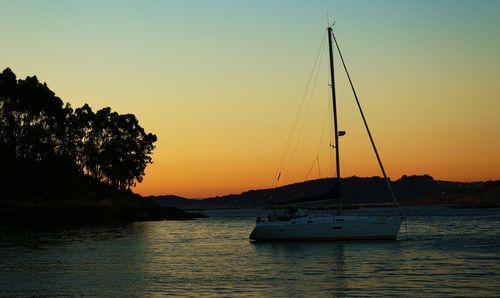 Boats in sea at sunset