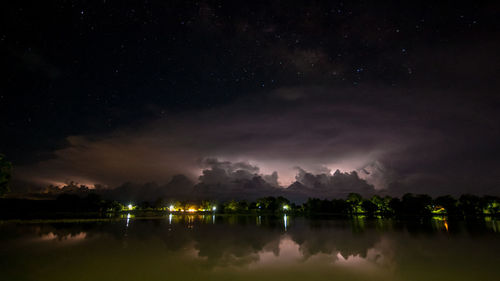 Scenic view of lake against sky at night