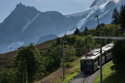 Train by mountains against sky