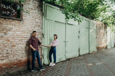 Friends standing against wall