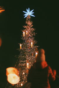 Illuminated christmas tree against sky at night