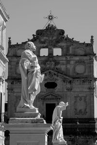 Statue against temple building against sky