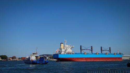 Ship in sea against clear blue sky