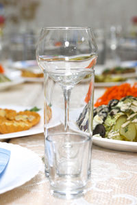 Empty wine glasses, a shot glass and a glass on the festive table with dishes.